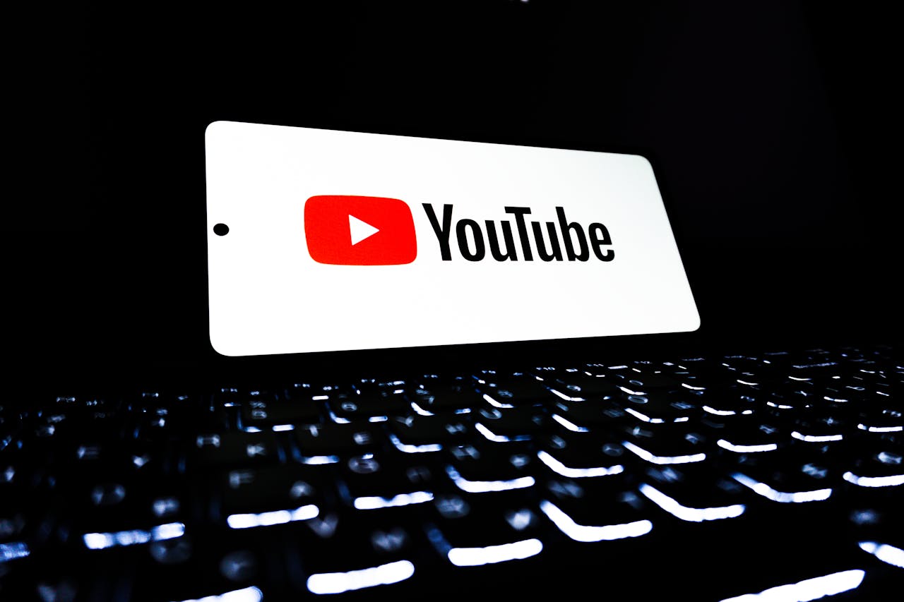 about-02 YouTube app icon displayed on a smartphone over an illuminated keyboard, representing digital media and online streaming.